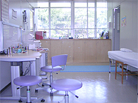 診察室の画像です。担当医用の机と簡易ベッドがあります。